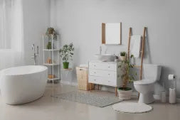 Modern bathroom with white fixtures, plants, and decor.