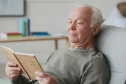Man reading a book in a cozy living room setting